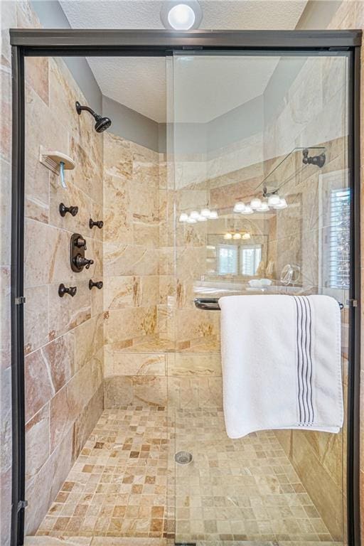 bathroom with a textured ceiling and a shower with shower door