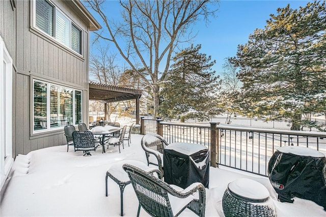 snow covered deck with a pergola and a grill