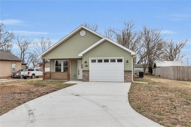 view of front of property with a garage, a porch, and central AC