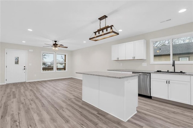 kitchen featuring ceiling fan, decorative light fixtures, stainless steel dishwasher, white cabinets, and sink