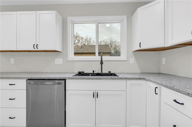 kitchen featuring stainless steel dishwasher, sink, and white cabinetry