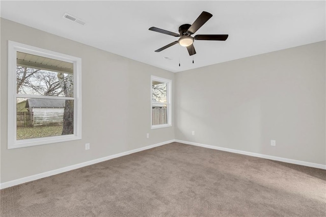 carpeted spare room featuring ceiling fan