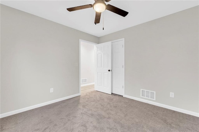 carpeted spare room with ceiling fan