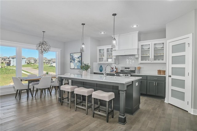 kitchen featuring gray cabinetry, premium range hood, hanging light fixtures, stainless steel gas range, and white cabinetry