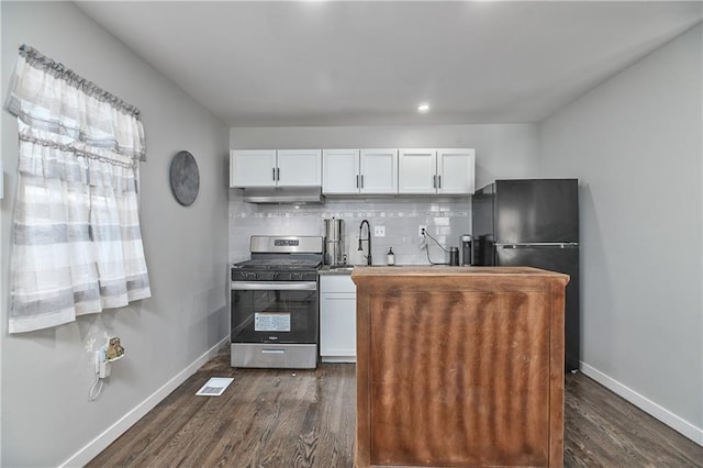 kitchen featuring white cabinetry, black fridge, gas stove, and decorative backsplash