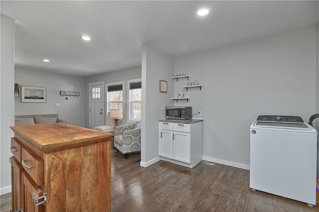 kitchen featuring dark hardwood / wood-style flooring, washer / clothes dryer, and white cabinets