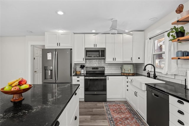 kitchen featuring open shelves, white cabinetry, stainless steel appliances, and a sink