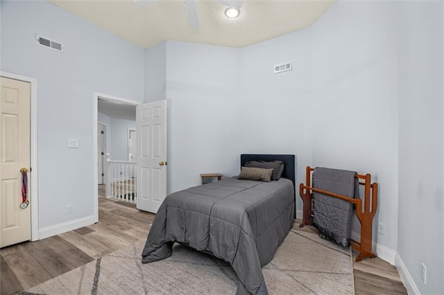 bedroom featuring baseboards, visible vents, and wood finished floors