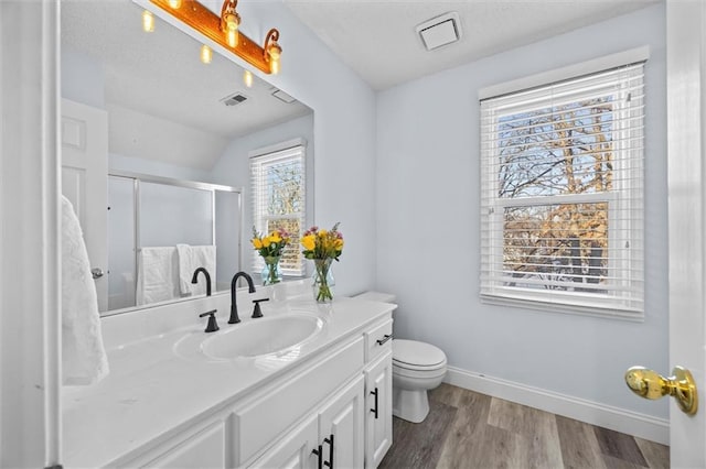 bathroom featuring a stall shower, baseboards, toilet, wood finished floors, and vanity