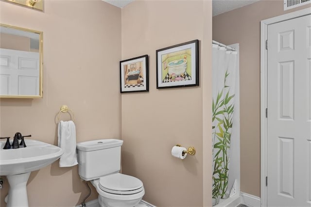 bathroom with toilet, a shower with curtain, and visible vents