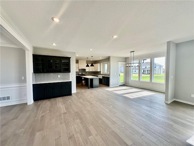 unfurnished living room with a textured ceiling and light hardwood / wood-style flooring