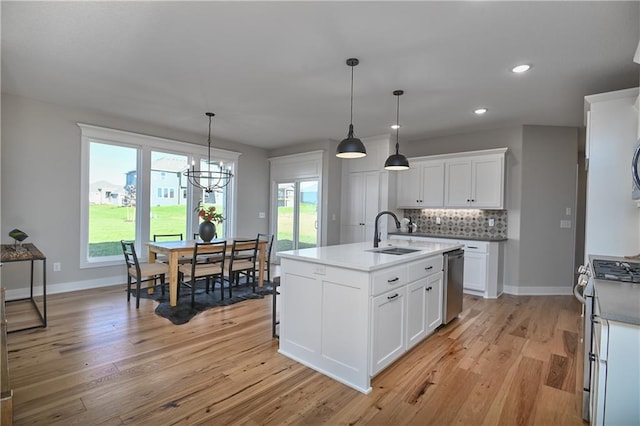 kitchen featuring white cabinetry, sink, stainless steel appliances, tasteful backsplash, and pendant lighting