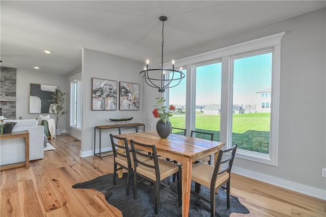 dining room with plenty of natural light, light wood-type flooring, and a chandelier