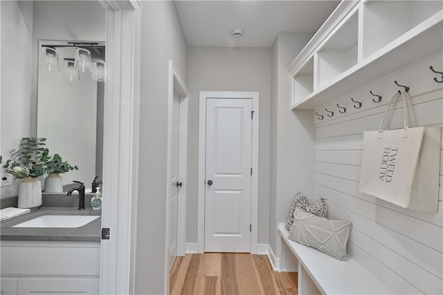 mudroom with sink and light hardwood / wood-style flooring