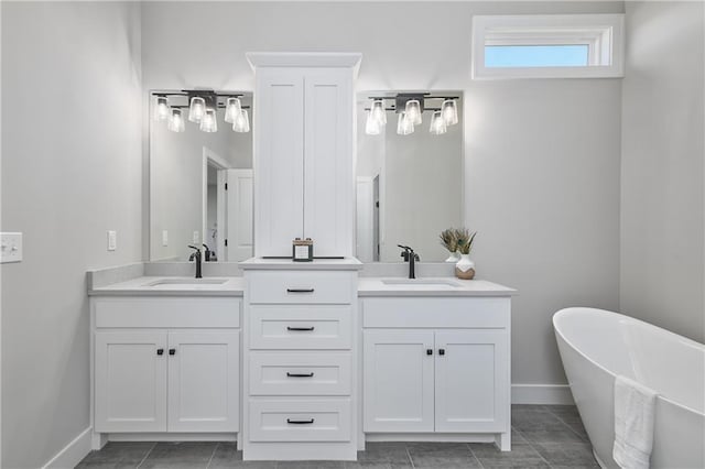 bathroom featuring tile patterned floors, a washtub, and vanity