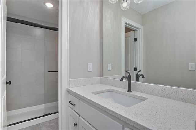 bathroom featuring tile patterned flooring, vanity, and an enclosed shower