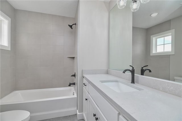 full bathroom with tile patterned floors, vanity, toilet, and tiled shower / bath combo