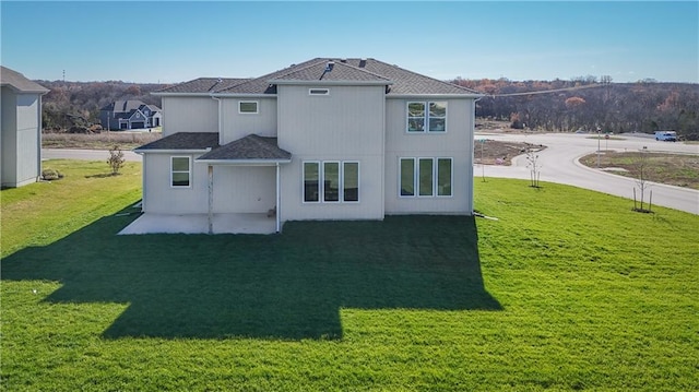 rear view of property with a yard and a patio