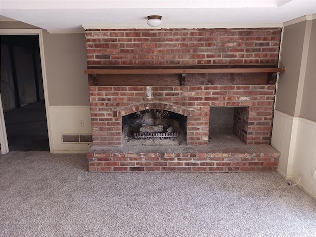 details with carpet flooring, crown molding, and a brick fireplace