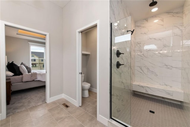 bathroom featuring tiled shower and toilet