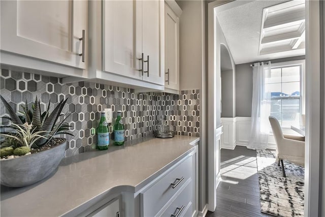 interior space featuring tasteful backsplash, white cabinetry, dark hardwood / wood-style flooring, and a textured ceiling