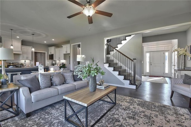 living room featuring ceiling fan and dark hardwood / wood-style flooring