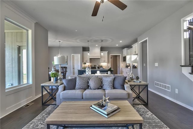 living room featuring dark hardwood / wood-style floors and ceiling fan