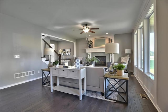 living room featuring ceiling fan and dark wood-type flooring