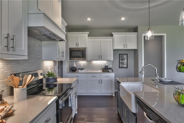 kitchen with decorative backsplash, stainless steel range with electric stovetop, built in microwave, sink, and white cabinets