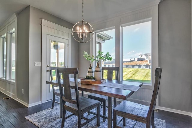 dining space with dark wood-type flooring and a notable chandelier