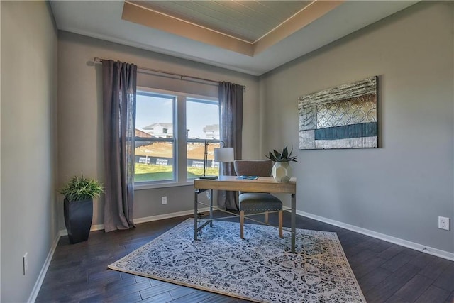 office space with dark hardwood / wood-style flooring and a tray ceiling