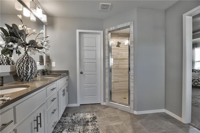 bathroom featuring tile patterned flooring, vanity, and an enclosed shower