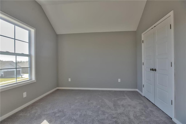 unfurnished bedroom featuring lofted ceiling and light carpet