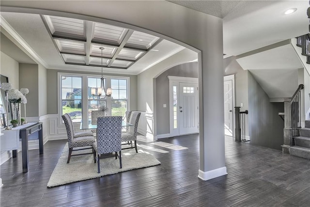 dining room with coffered ceiling, an inviting chandelier, beamed ceiling, dark hardwood / wood-style floors, and crown molding