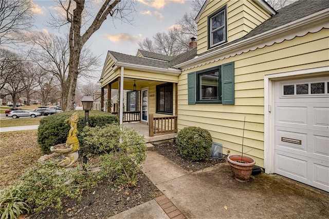 view of exterior entry with a garage and covered porch