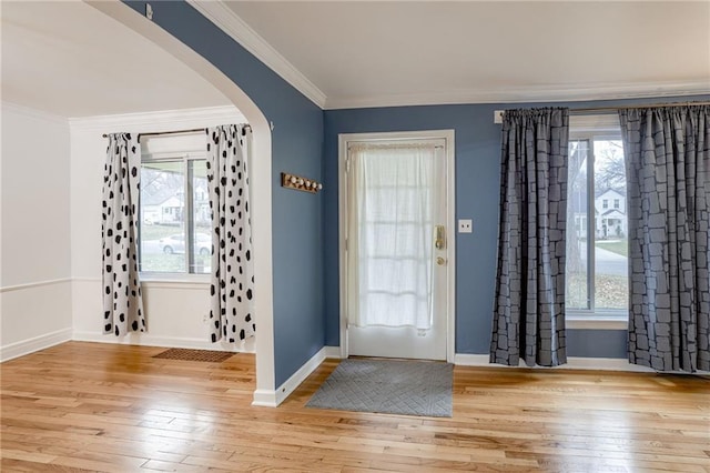 entrance foyer with light hardwood / wood-style flooring, a wealth of natural light, and ornamental molding