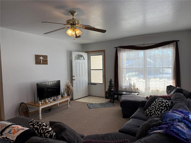 living room with a textured ceiling, ceiling fan, and light colored carpet