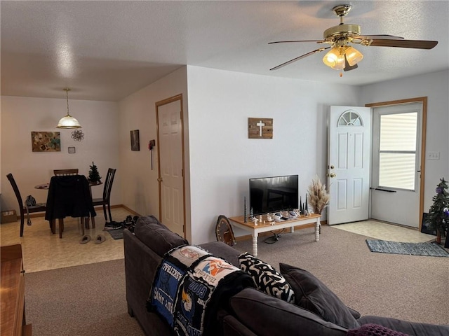 carpeted living room with a textured ceiling and ceiling fan