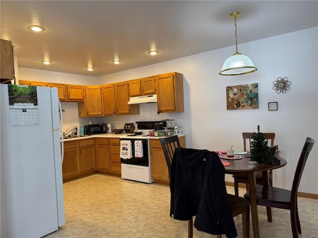 kitchen featuring white appliances and decorative light fixtures