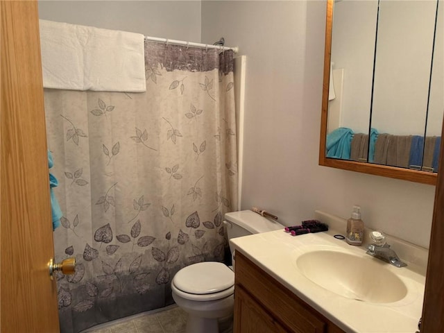 bathroom featuring toilet, tile patterned floors, walk in shower, and vanity