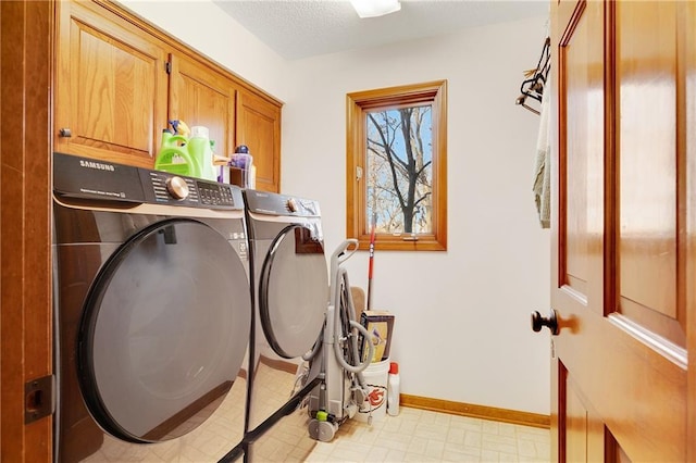 laundry room with cabinet space, baseboards, washer and clothes dryer, and light floors