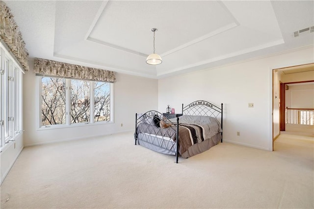 bedroom with baseboards, a raised ceiling, visible vents, and light colored carpet