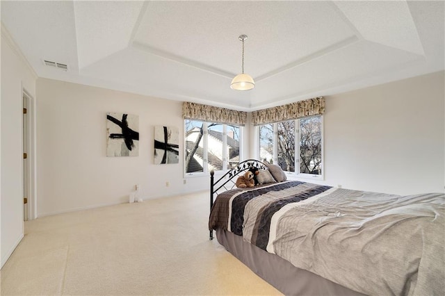 carpeted bedroom featuring a tray ceiling, visible vents, and baseboards