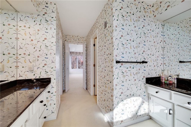 bathroom with vanity and wallpapered walls