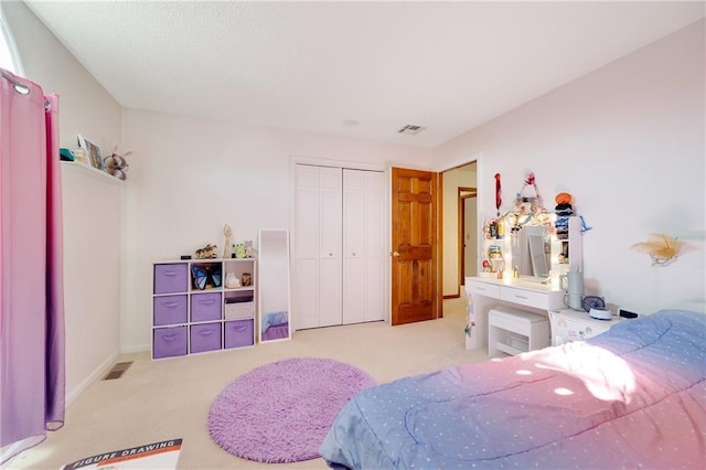 carpeted bedroom featuring a closet, visible vents, and baseboards