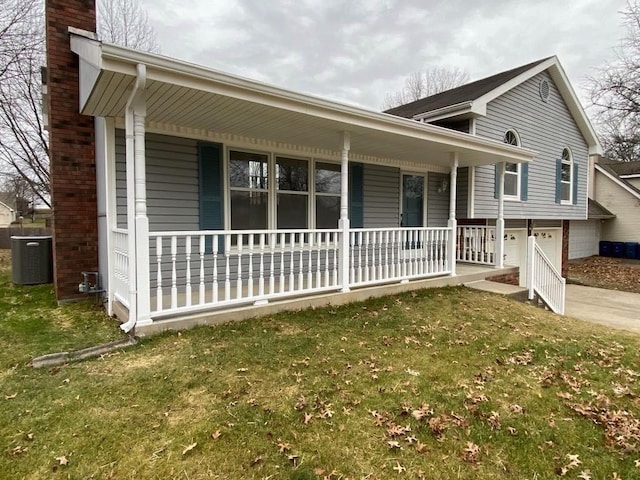 view of front of house with a garage, a front yard, central AC unit, and a porch