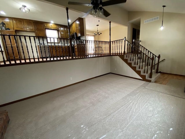 interior space with lofted ceiling, light colored carpet, and ceiling fan