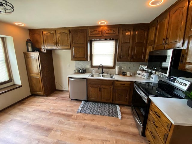 kitchen featuring light hardwood / wood-style floors, sink, stainless steel appliances, and tasteful backsplash