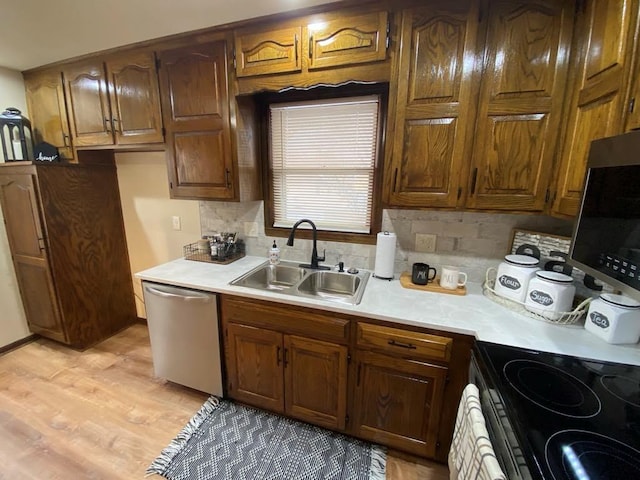 kitchen with stainless steel appliances, decorative backsplash, light hardwood / wood-style flooring, and sink