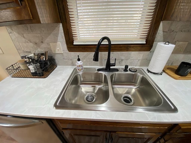 room details featuring stainless steel dishwasher, tasteful backsplash, dark brown cabinetry, and sink